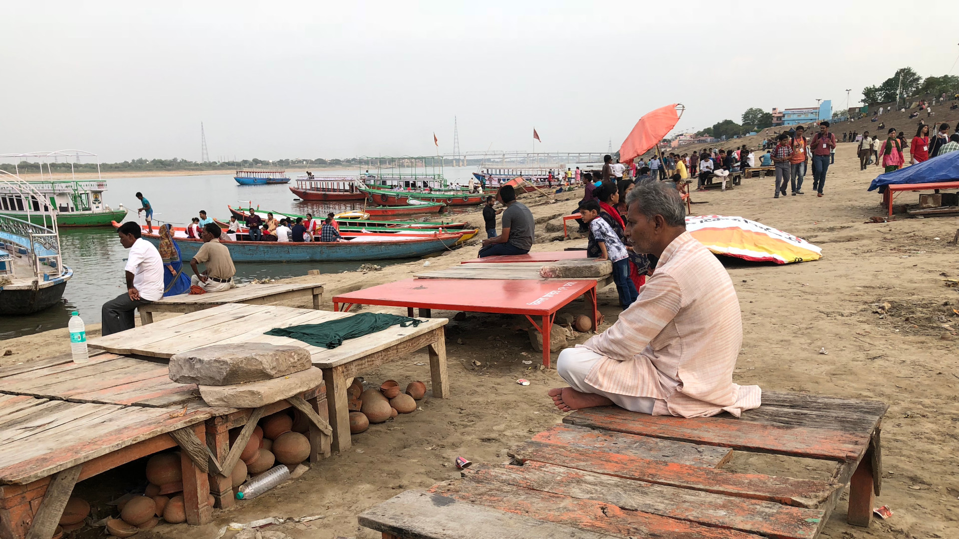 An Indian man sitting facing the river Ganges