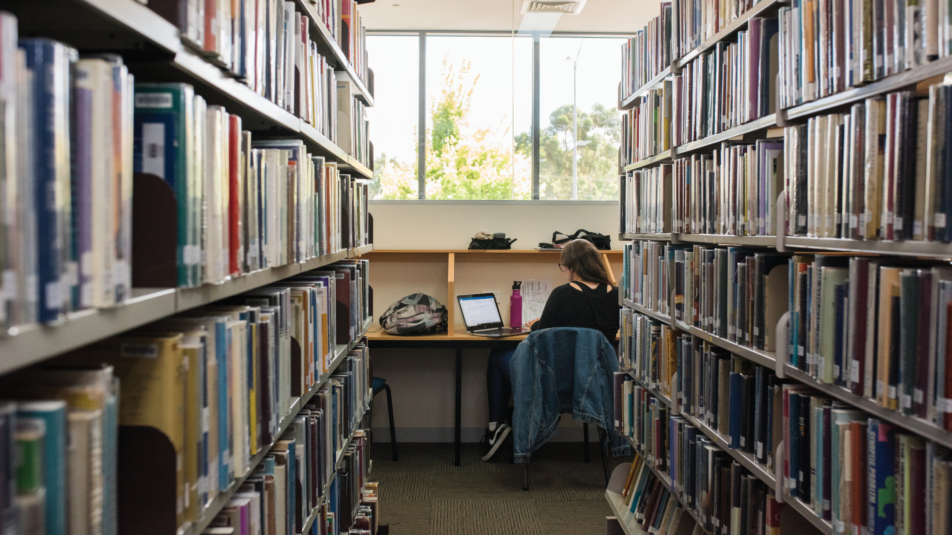 MST Library pictured with books on either side, looking at a student studying